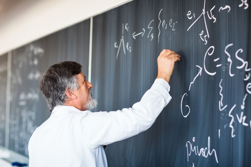 Un profesor escribiendo fórmulas en una pizarra